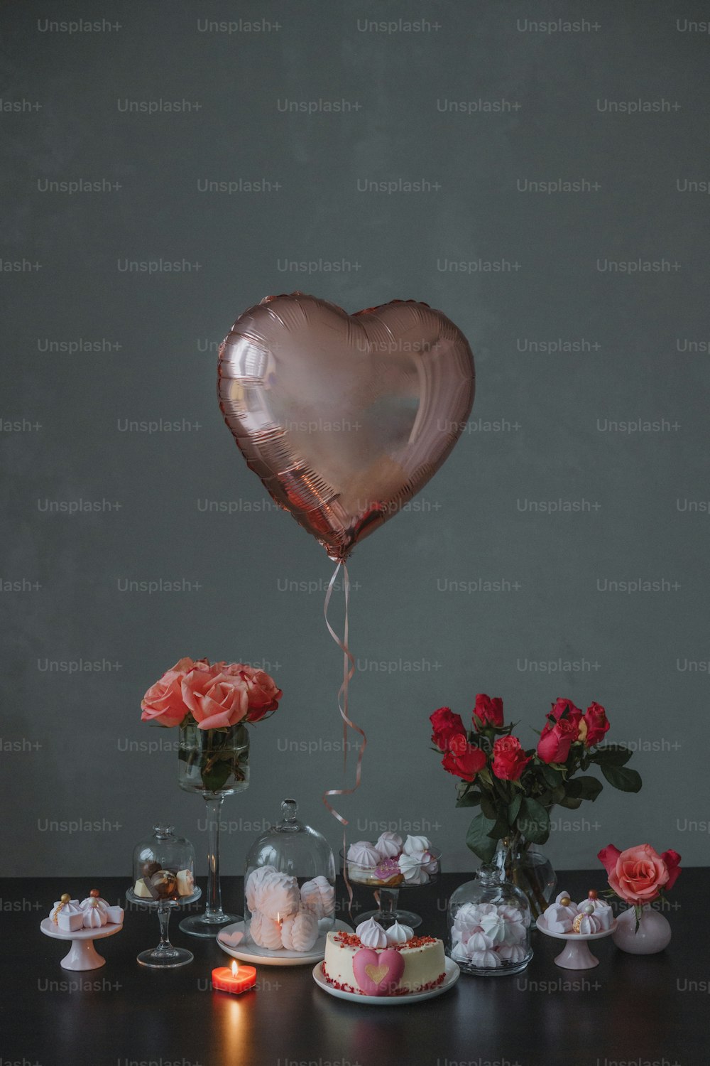 a table topped with cakes and a heart shaped balloon