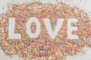 the word love spelled out of sprinkles on a white background
