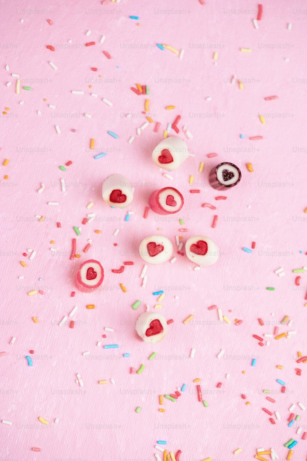a pink background with sprinkles and donuts