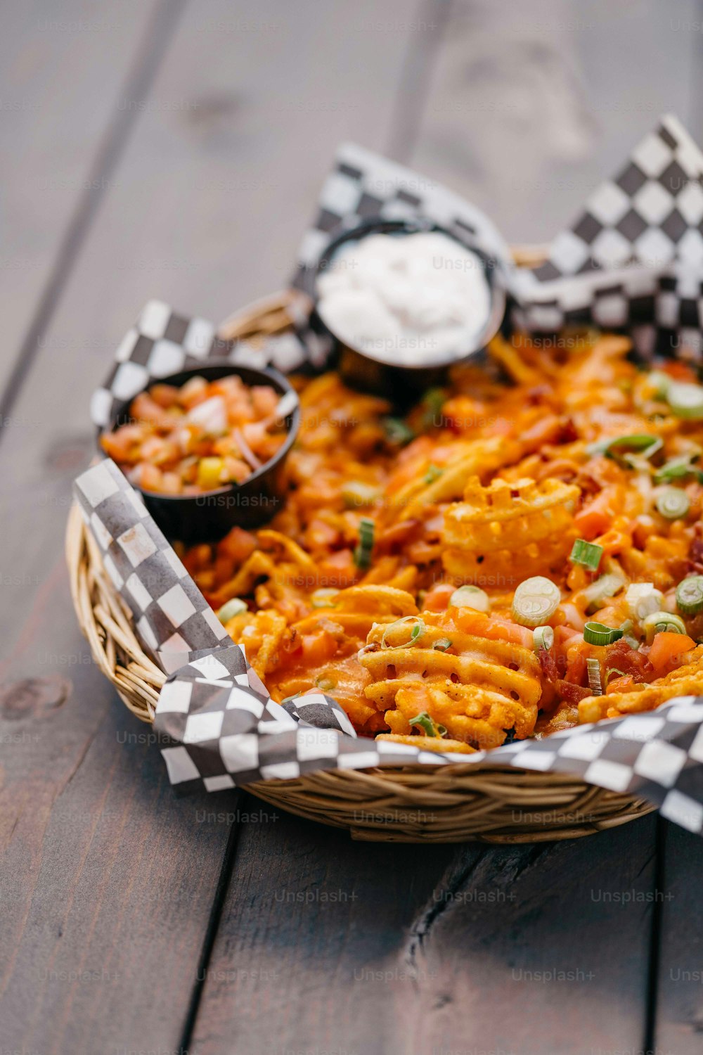 a basket filled with pasta and sauce on top of a wooden table