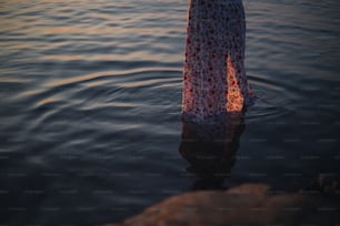 Una donna in un vestito in piedi nell'acqua