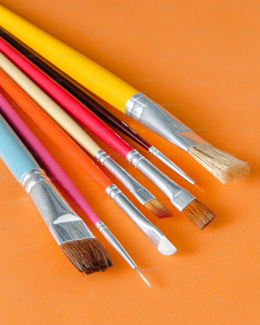 a bunch of paint brushes lined up in a row