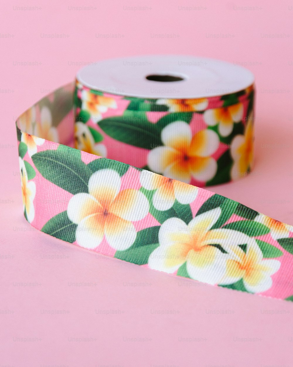 a roll of pink and yellow flowers on a pink background