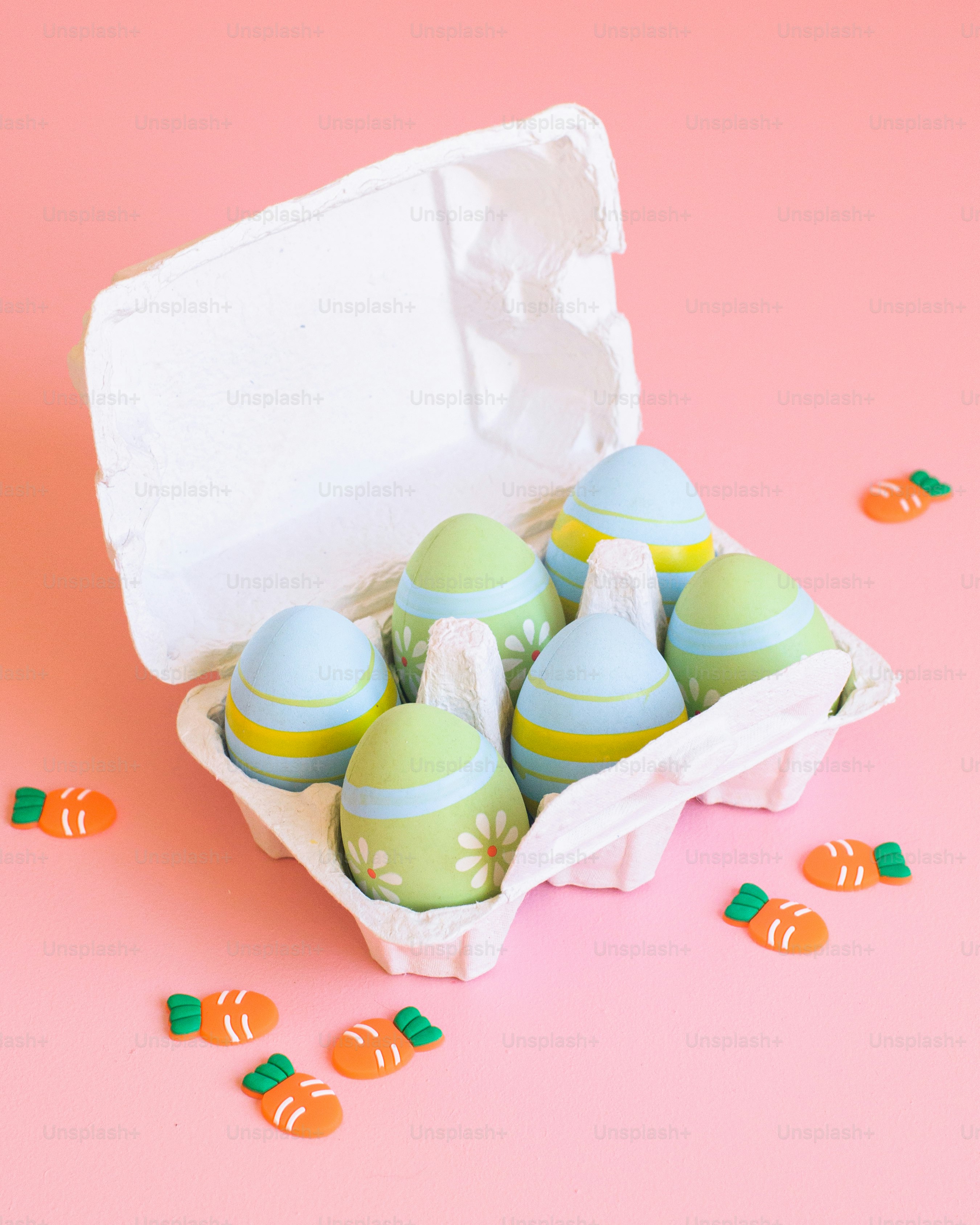 a carton of easter eggs on a pink background
