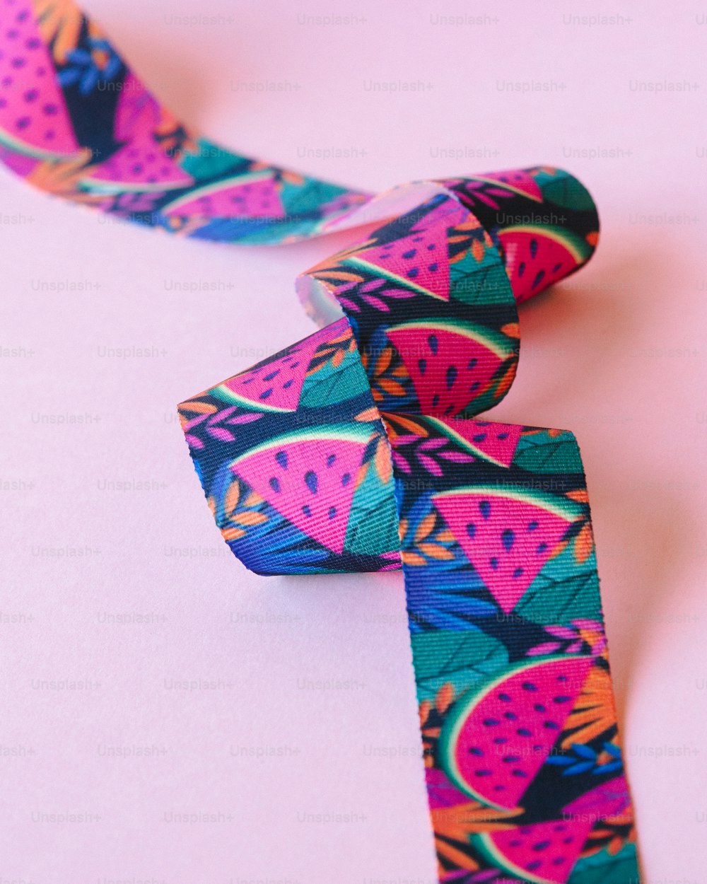a close up of a tie on a pink surface