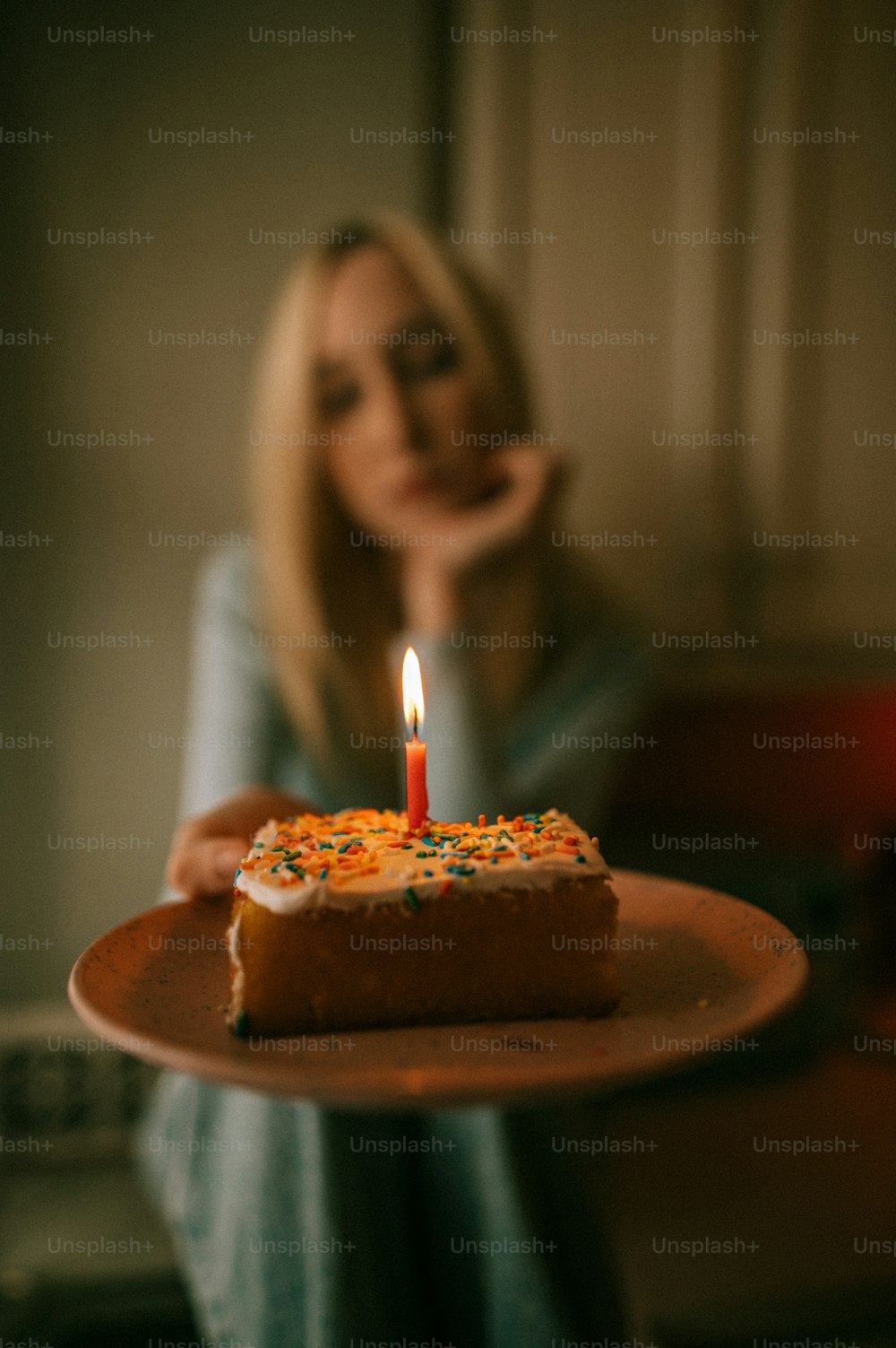 una donna che tiene un piatto con un pezzo di torta su di esso
