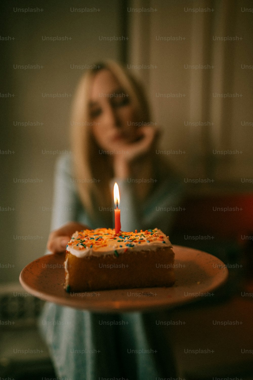 a woman holding a plate with a piece of cake on it