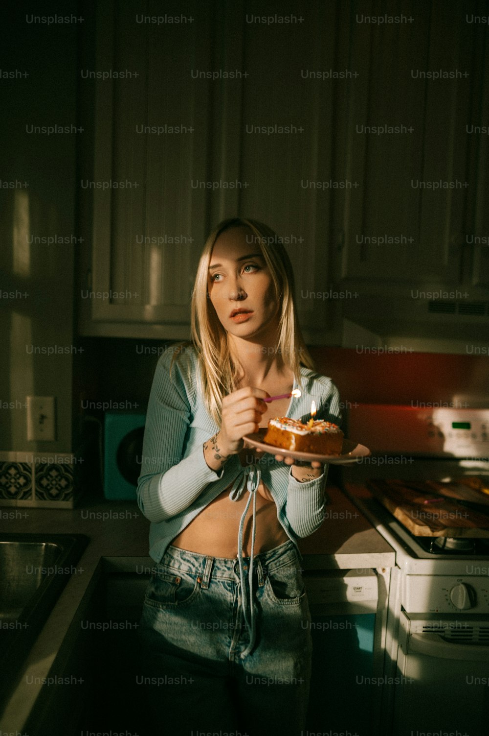 uma mulher em uma cozinha segurando um pedaço de bolo