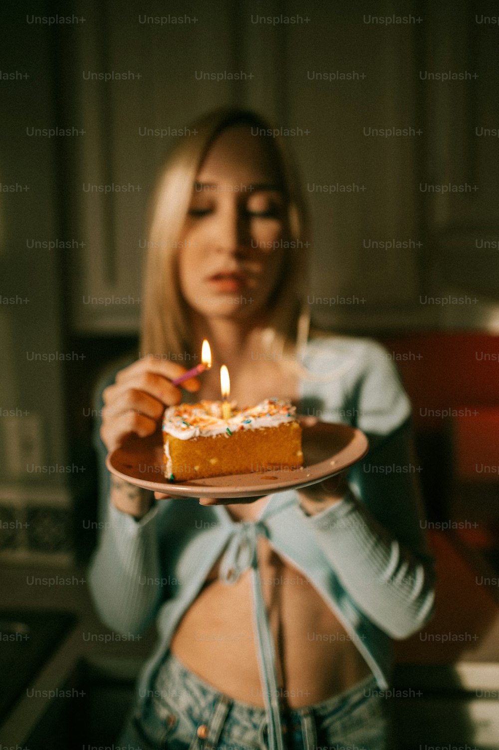 Eine Frau hält einen Teller mit einem Stück Kuchen darauf