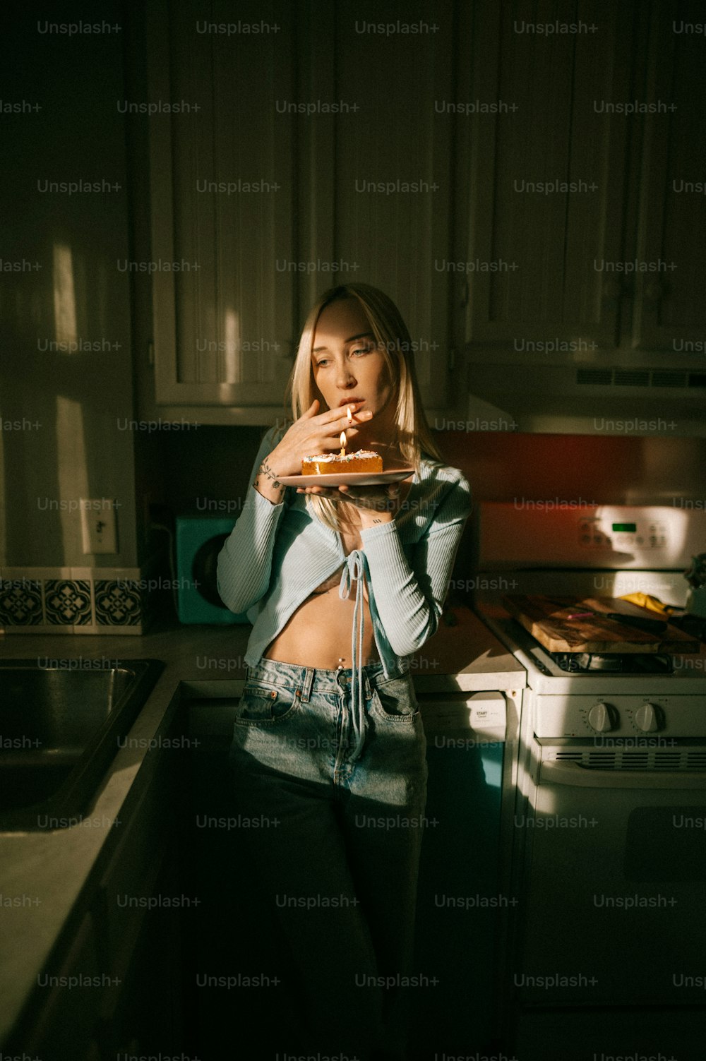 Eine Frau steht in einer Küche mit einer Pizza in der Hand