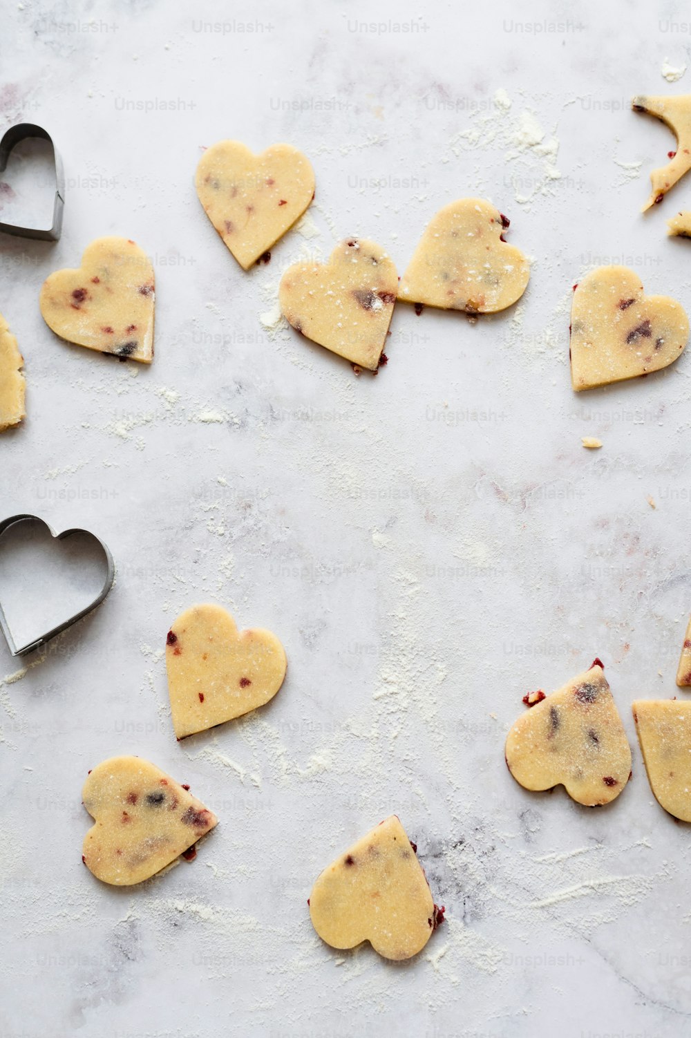 heart shaped cookies on a table with a cookie cutter