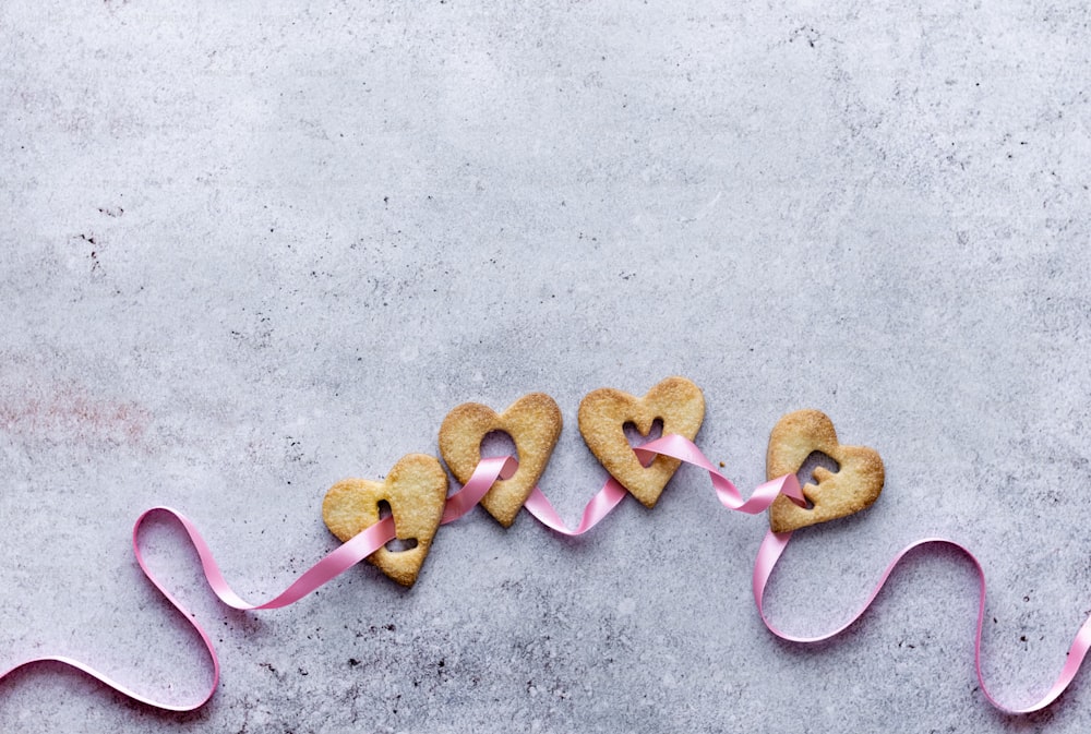 um par de biscoitos em forma de coração sentados em cima de uma mesa