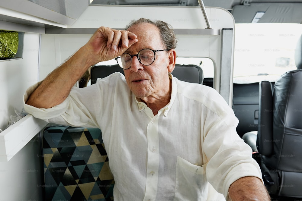 a man sitting in a chair with his hand on his head