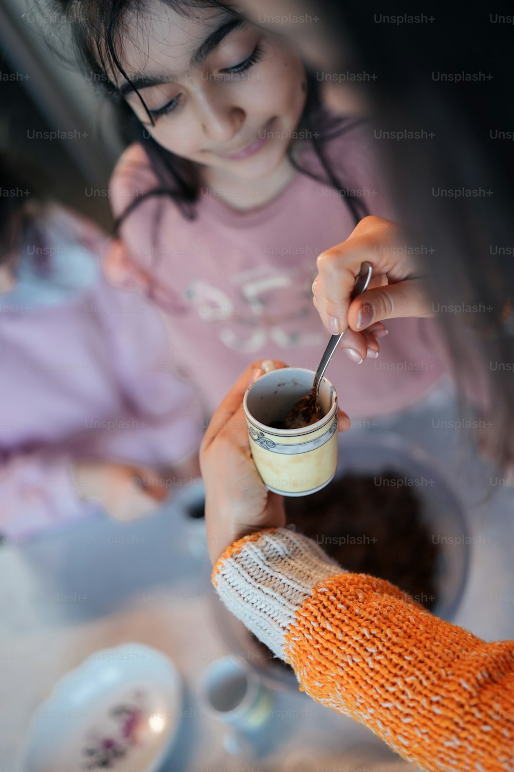 Una niña pequeña sosteniendo una taza de café