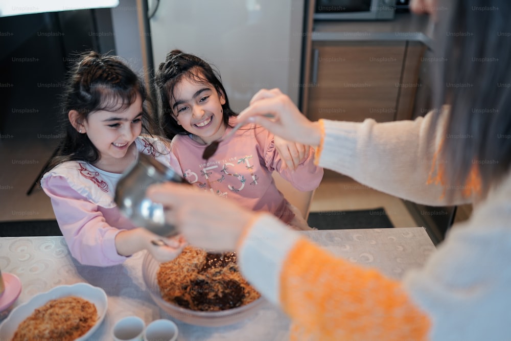 two little girls sitting at a table with doughnuts