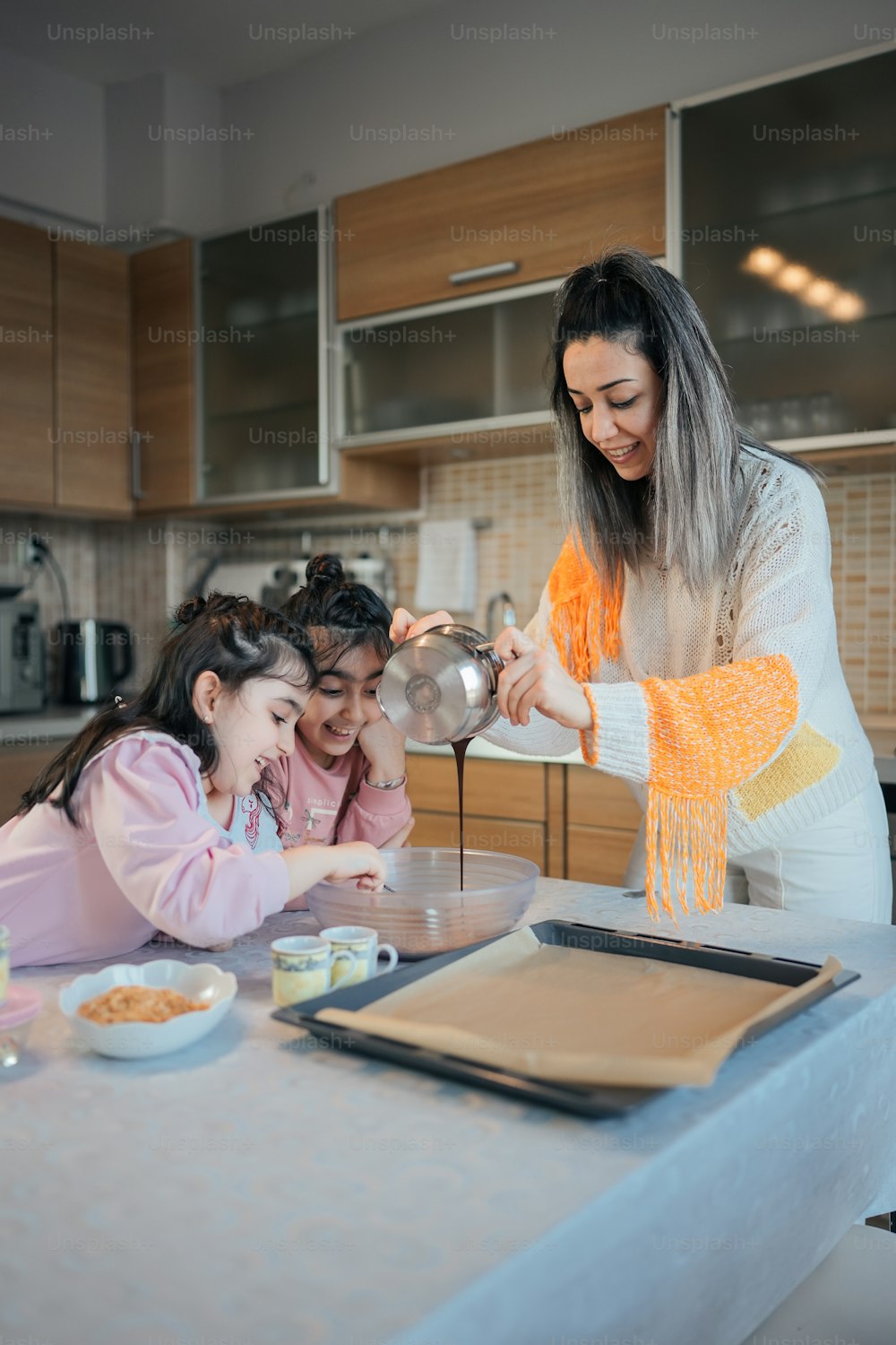 Une femme et deux jeunes filles dans une cuisine