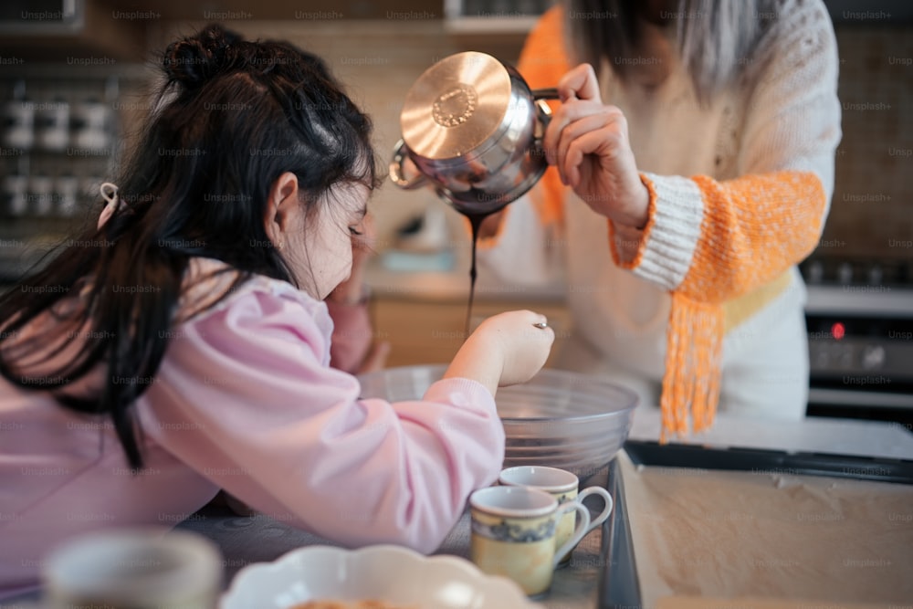 a woman pouring a cup of coffee into a child's hand
