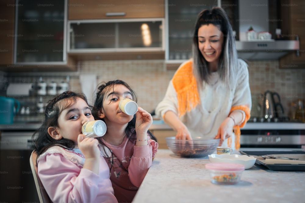 Eine Frau und zwei Kinder sitzen an einer Küchentheke