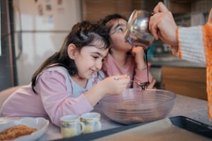 a woman and a little girl mixing something in a bowl
