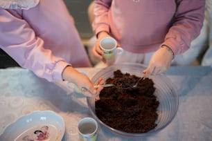 a woman is scooping chocolate cake into a bowl