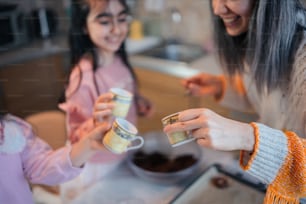 a woman and a little girl holding coffee cups