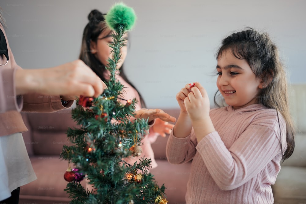 Una niña de pie junto a un árbol de Navidad