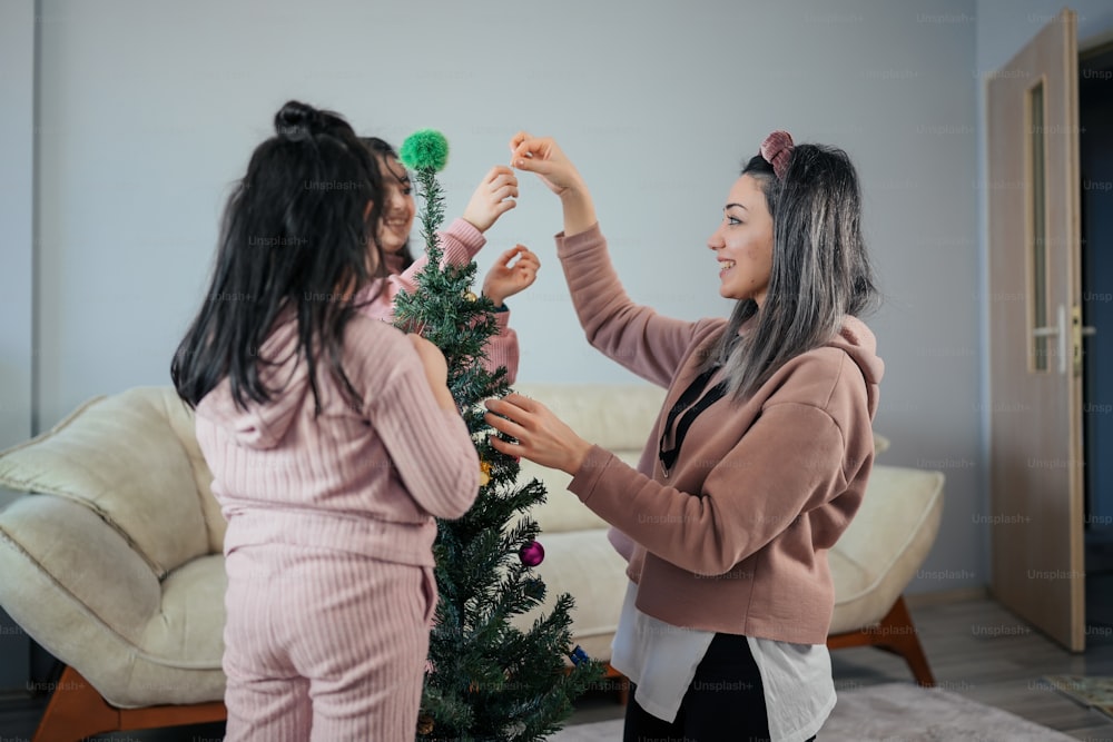 two women decorating a christmas tree together