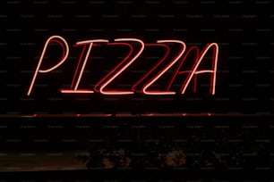 a pizza sign lit up in the dark