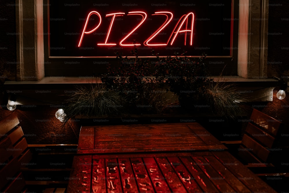 um sinal de néon vermelho que lê pizza nele