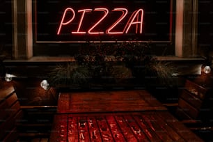 a red neon sign that reads pizza on it