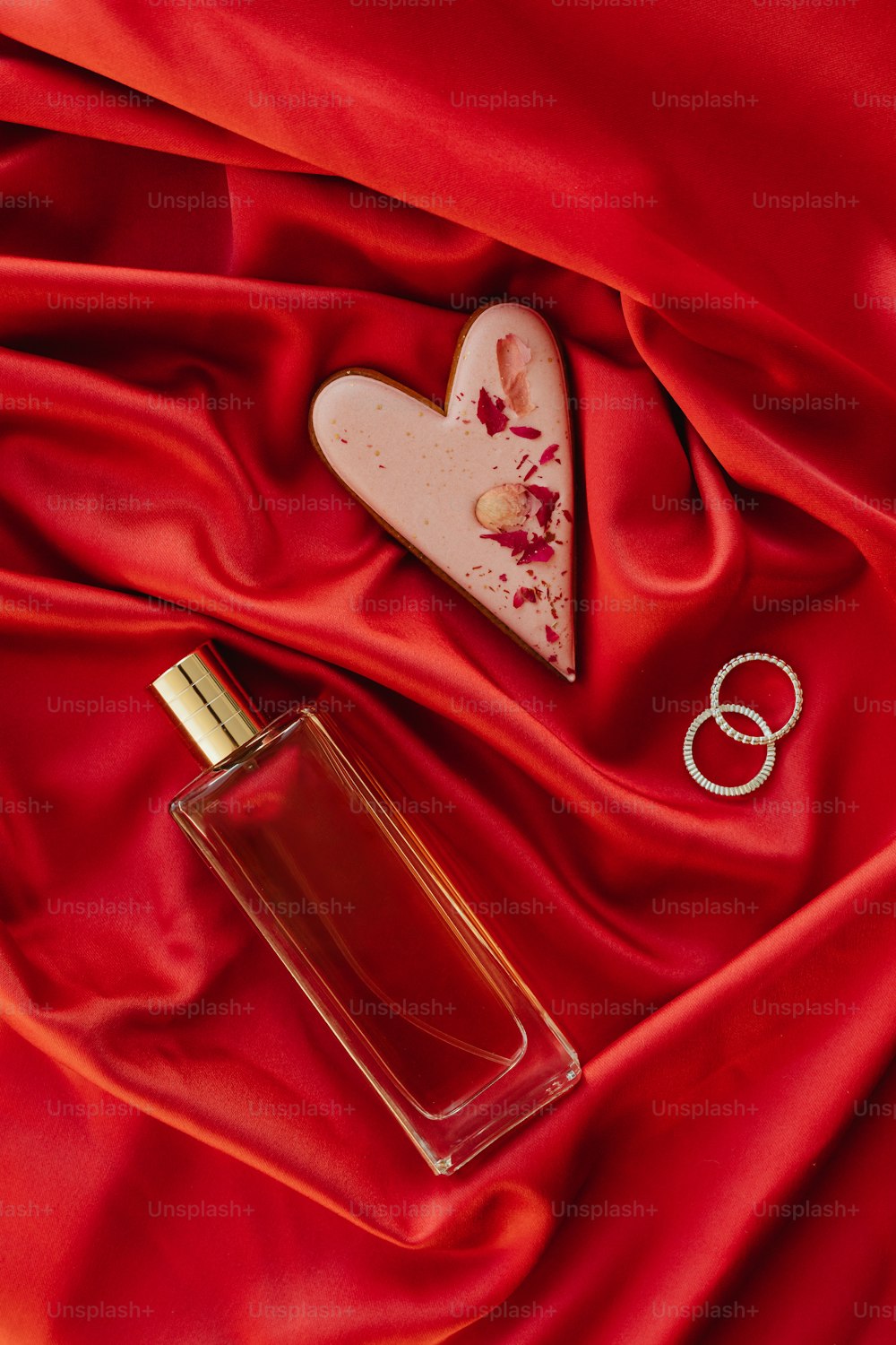 a bottle of perfume sitting on top of a red cloth