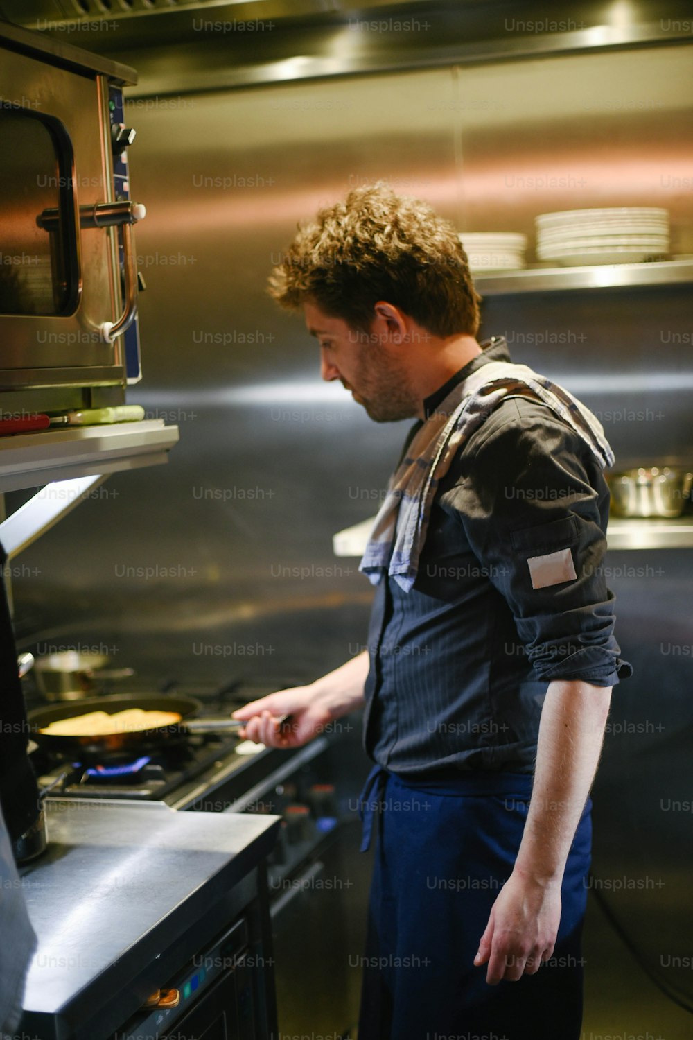 um homem em pé em uma cozinha preparando comida