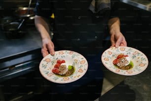 a person holding two plates with food on them