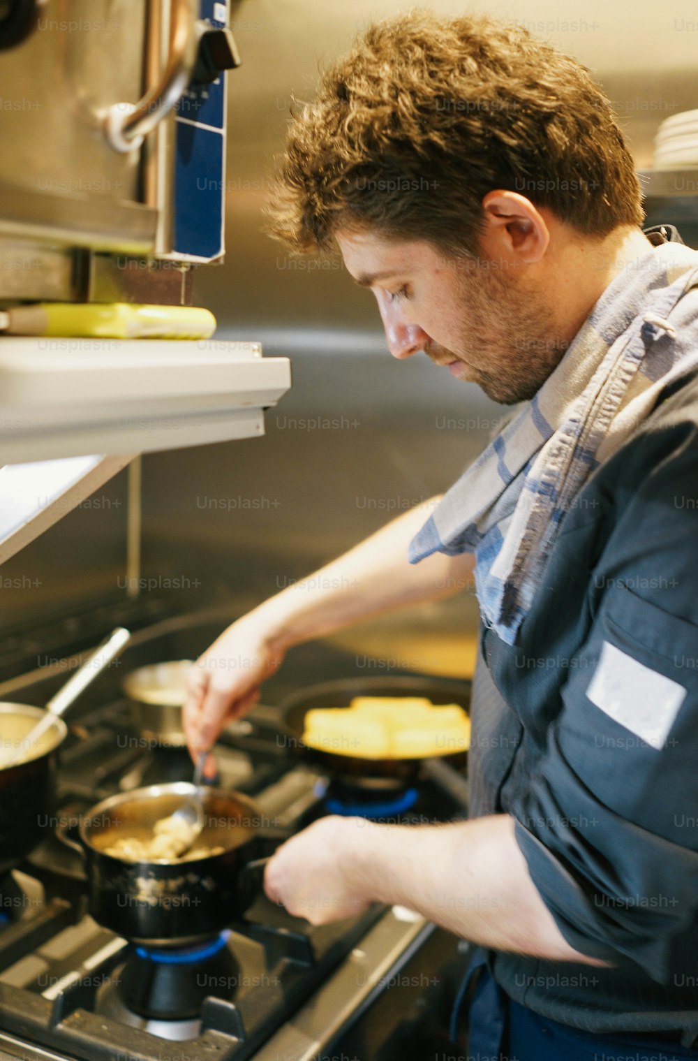 台所のストーブで料理をする男