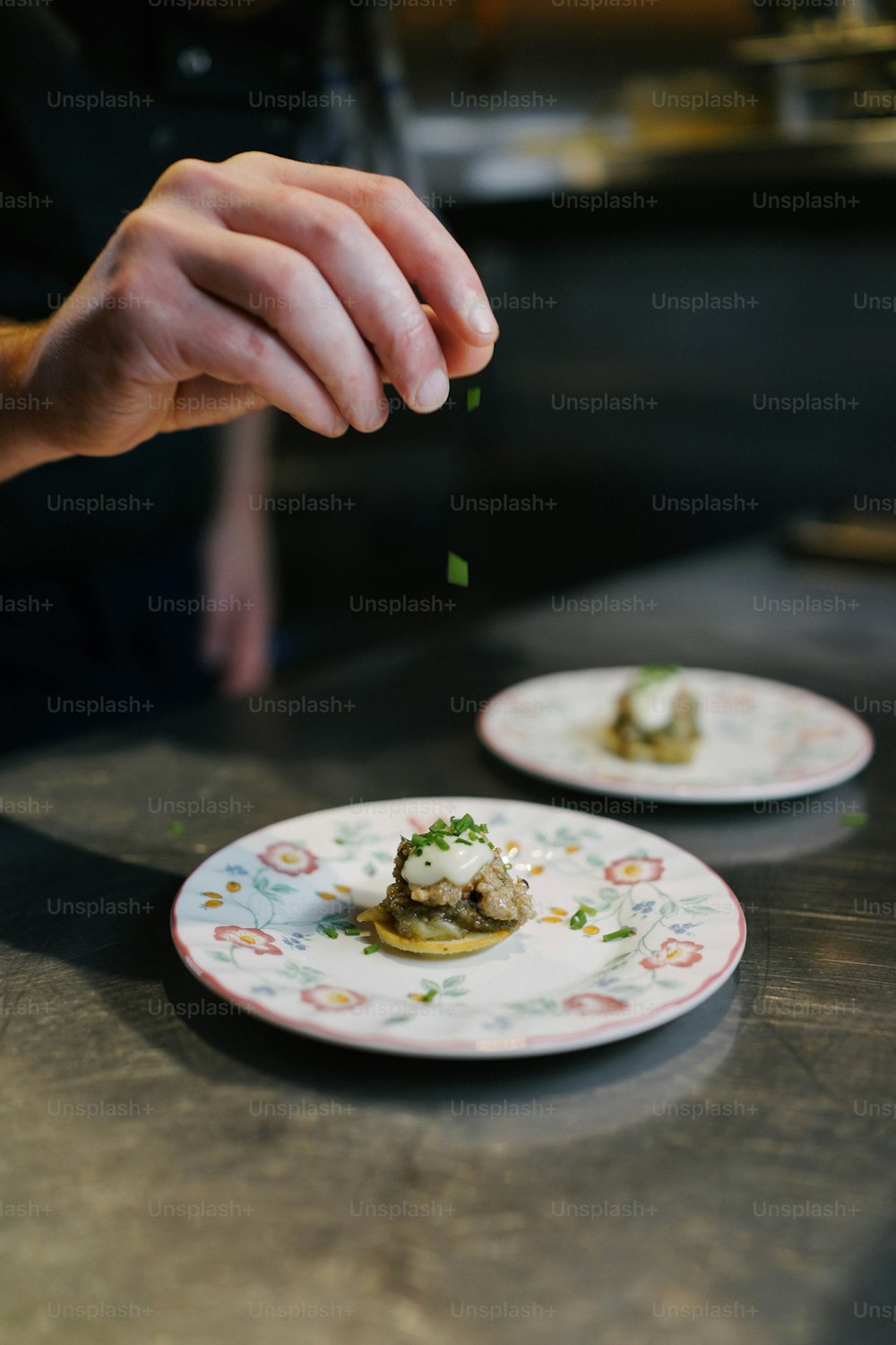 a person is sprinkling some food on a plate