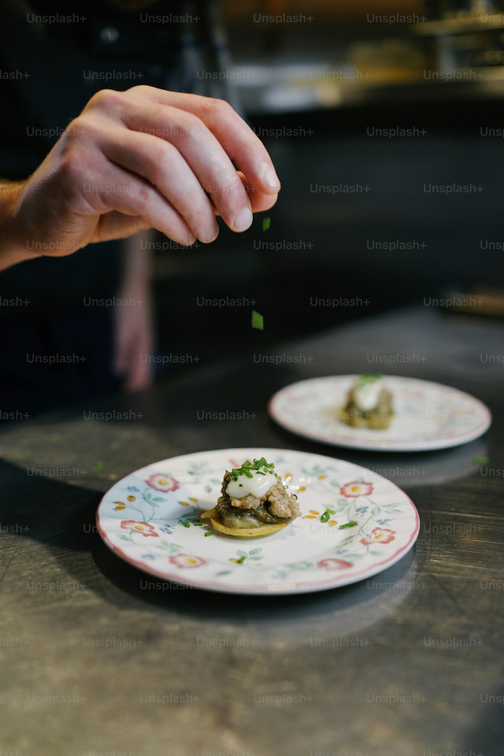 Una persona está rociando algo de comida en un plato