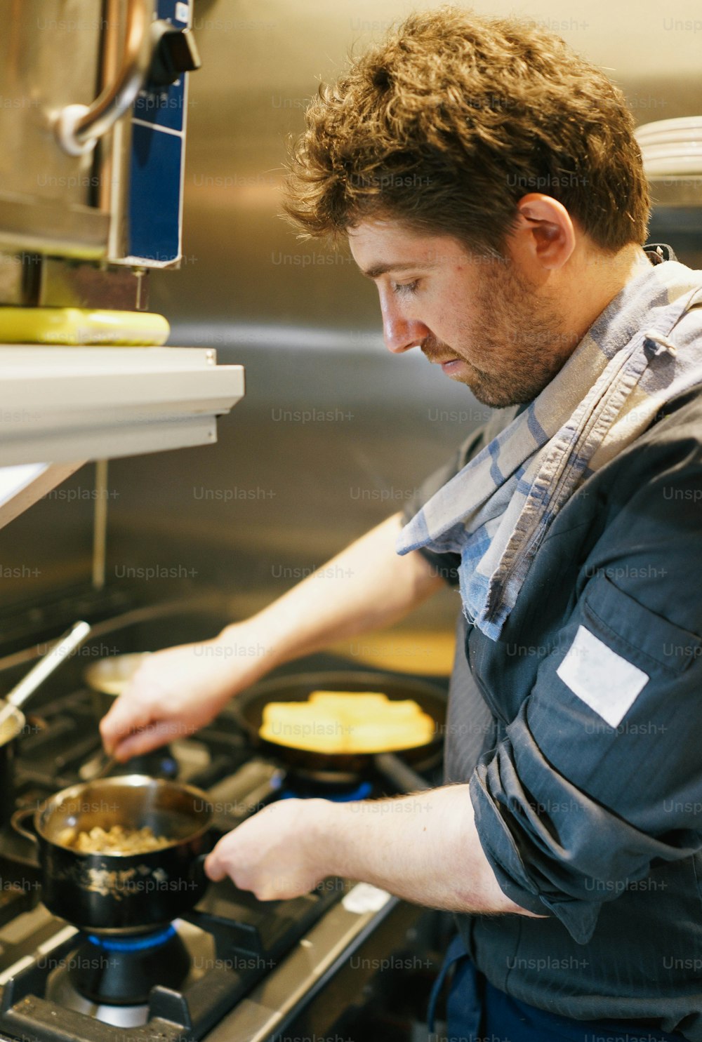 a man cooking food on a stove in a kitchen