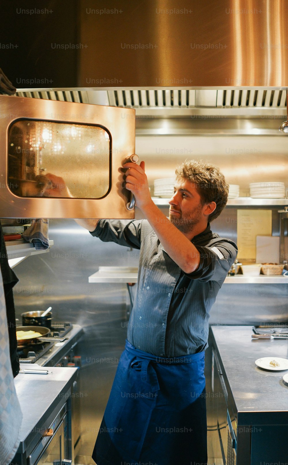 a man holding a microwave in a kitchen