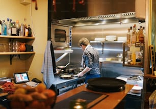 Ein Mann in einer Küche, der Essen auf einem Herd kocht