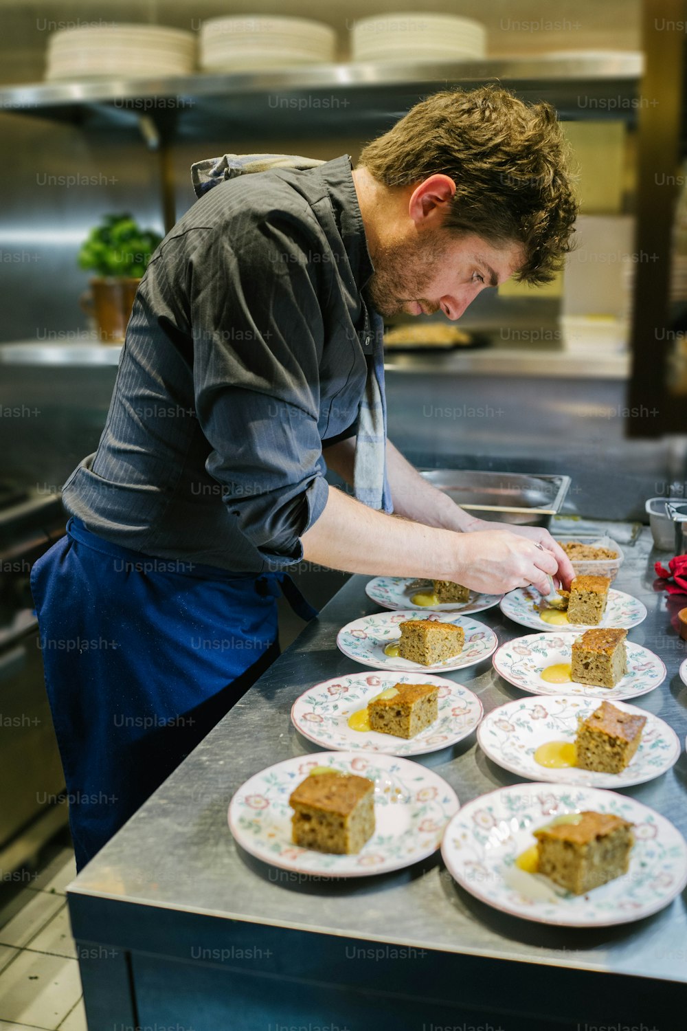 a man in a kitchen preparing food on plates