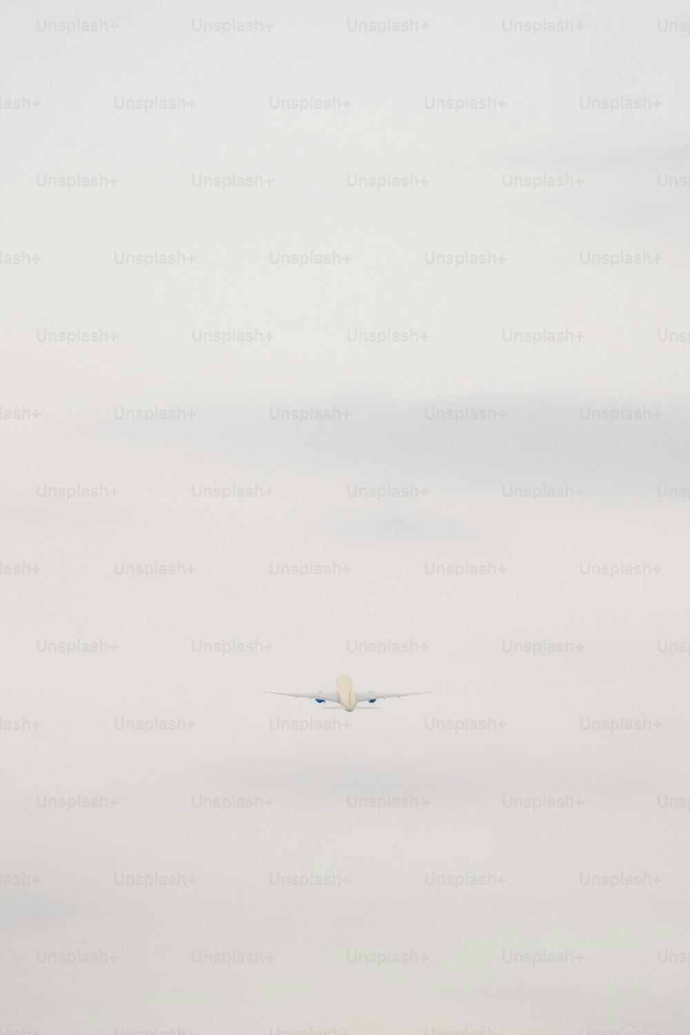 Ein Flugzeug fliegt am Himmel mit einer Wolke im Hintergrund