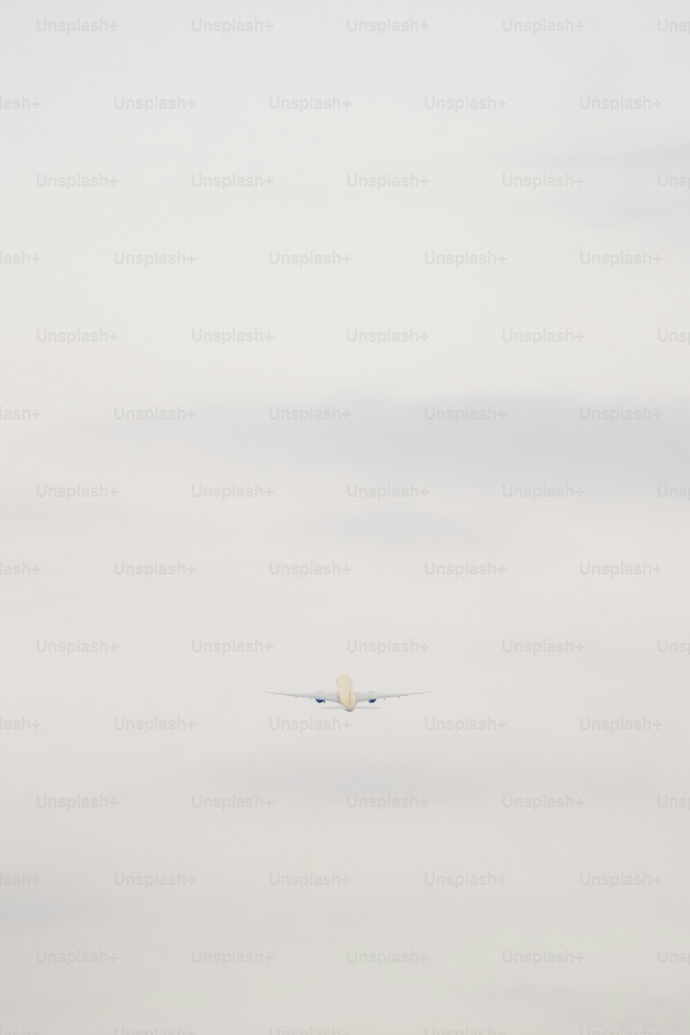 an airplane flying in the sky with a cloud in the background