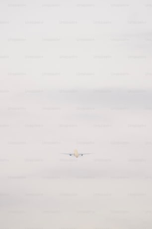 an airplane flying in the sky with a cloud in the background