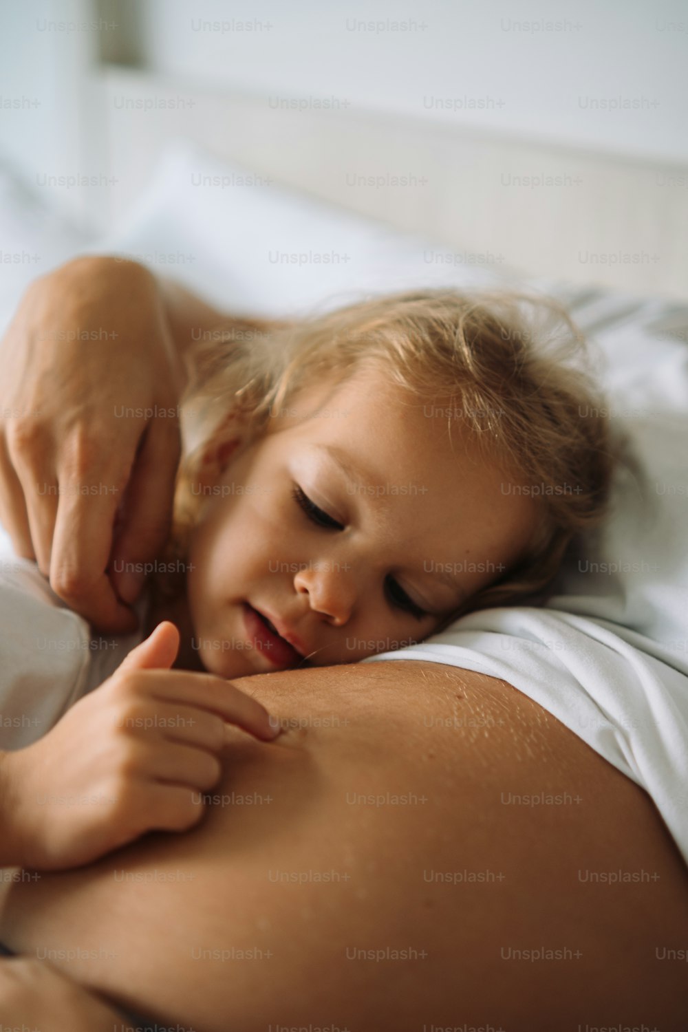 Una bambina che si trova nel letto con la sua madre