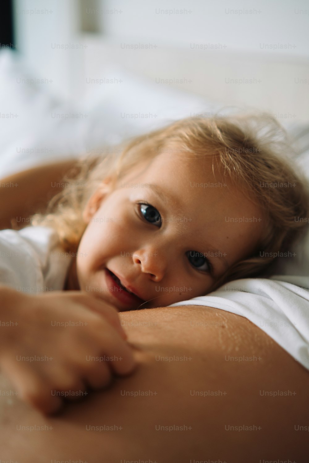 a little girl laying on top of a bed
