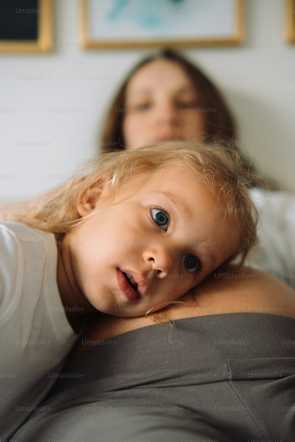 a woman and a child laying on a bed