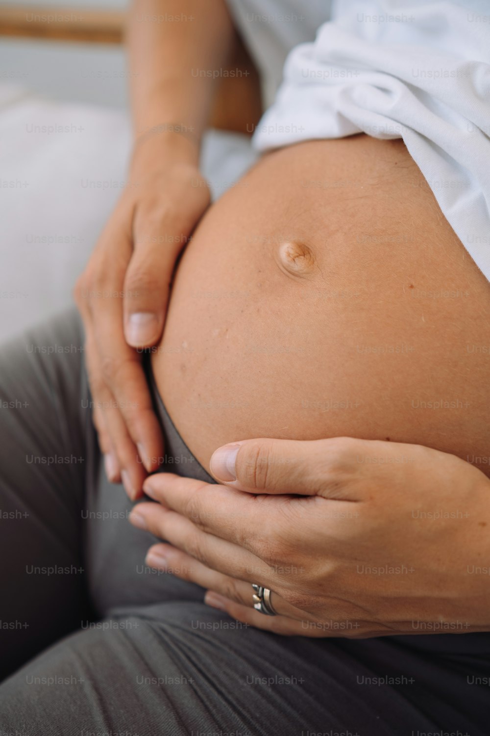 Eine schwangere Frau hält ihren Bauch in den Händen