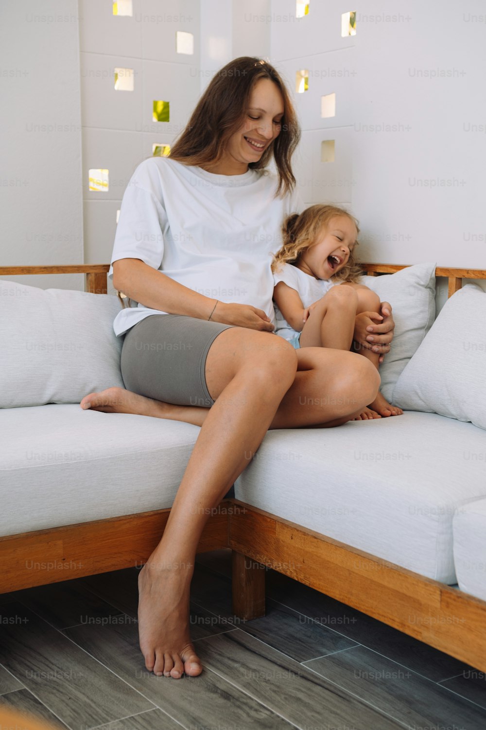 une femme assise sur un canapé tenant un bébé