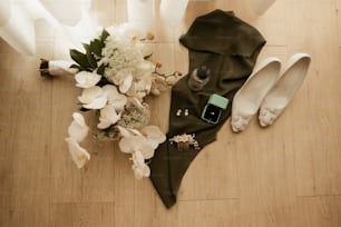 a bouquet of flowers and a pair of shoes on a wooden floor