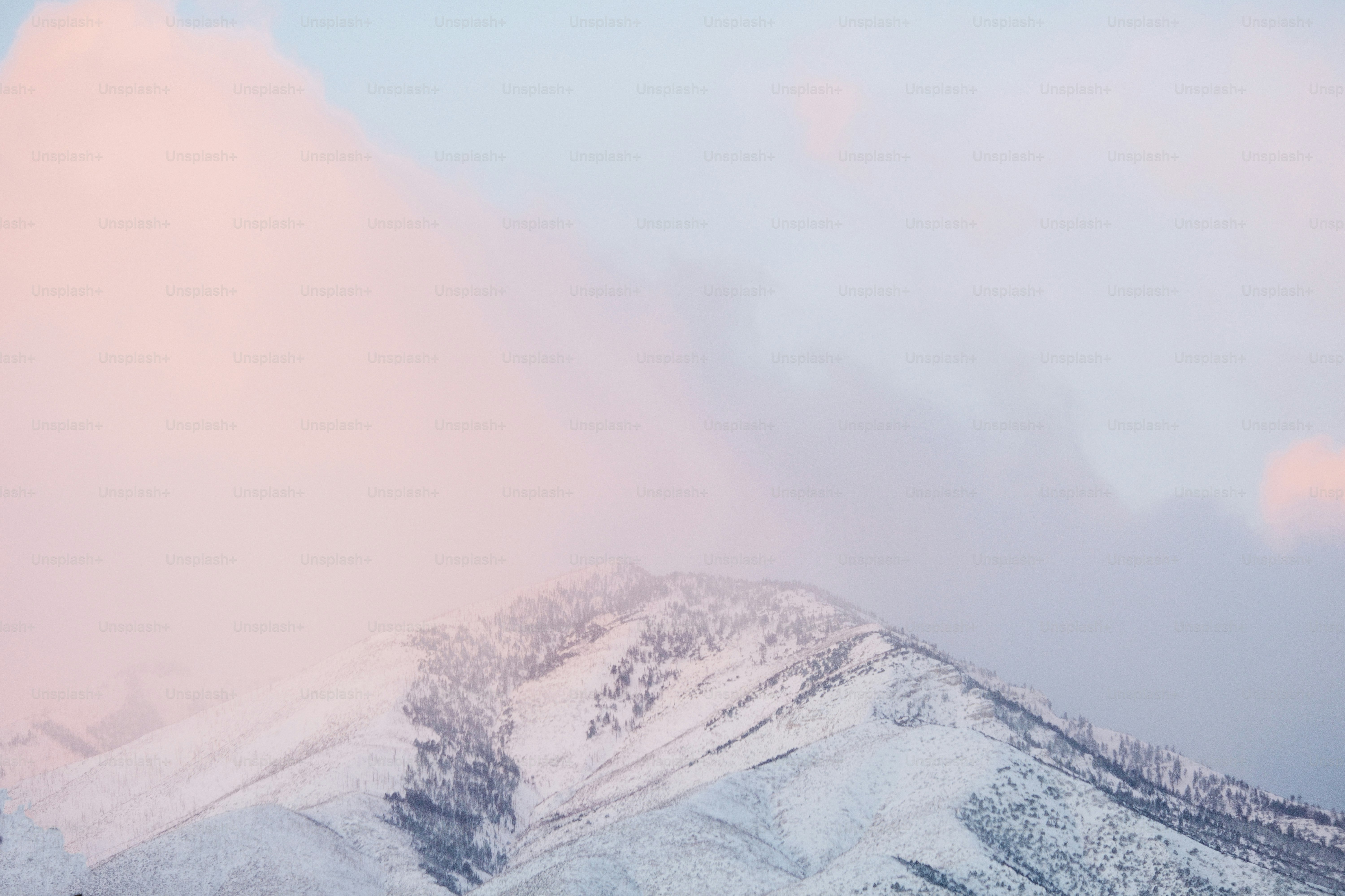 a mountain covered in snow under a cloudy sky